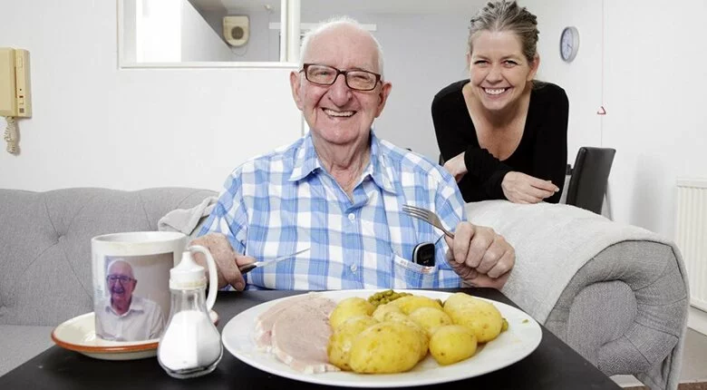 Older man and younger woman with a plate of food